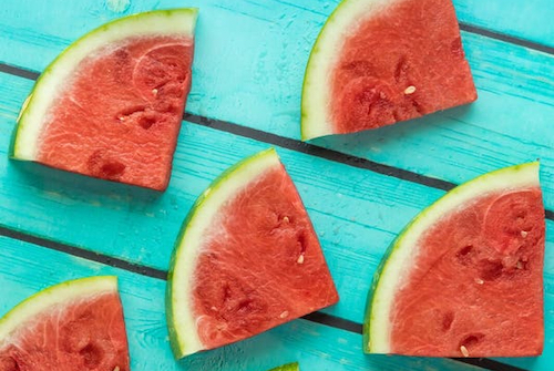 Watermelon slices on a teal table