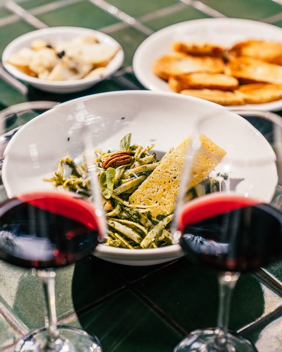 Serving of pasta with red wine in glasses